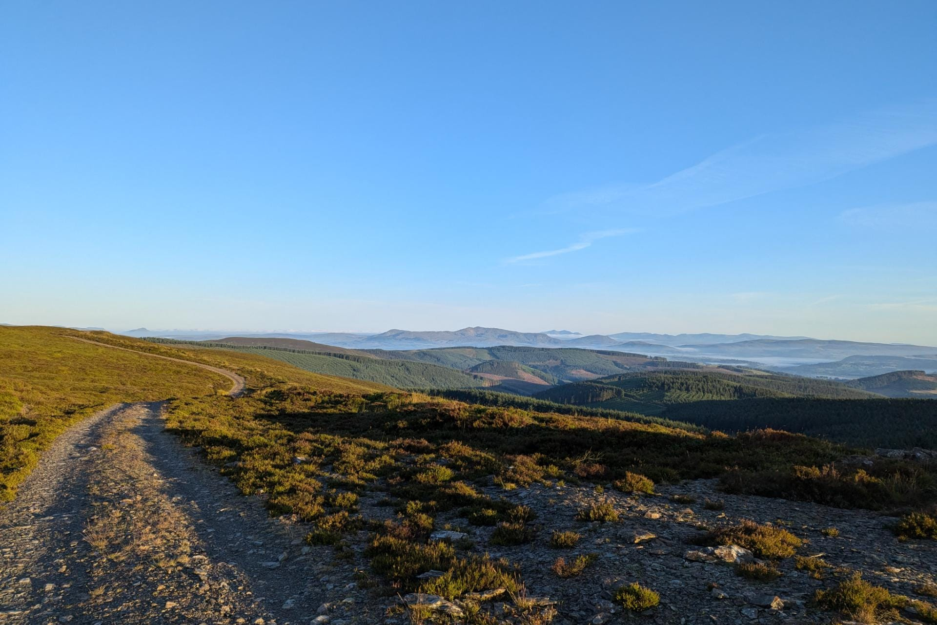 An exposed gravel track across the hills in evening light