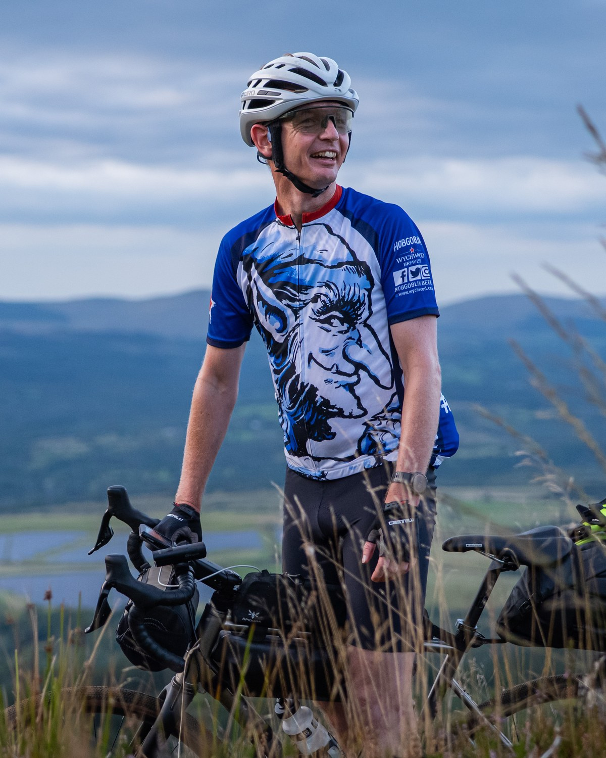 Joe Tresadern with his bike on a hillside above the valley at Mountains of the Merfynion