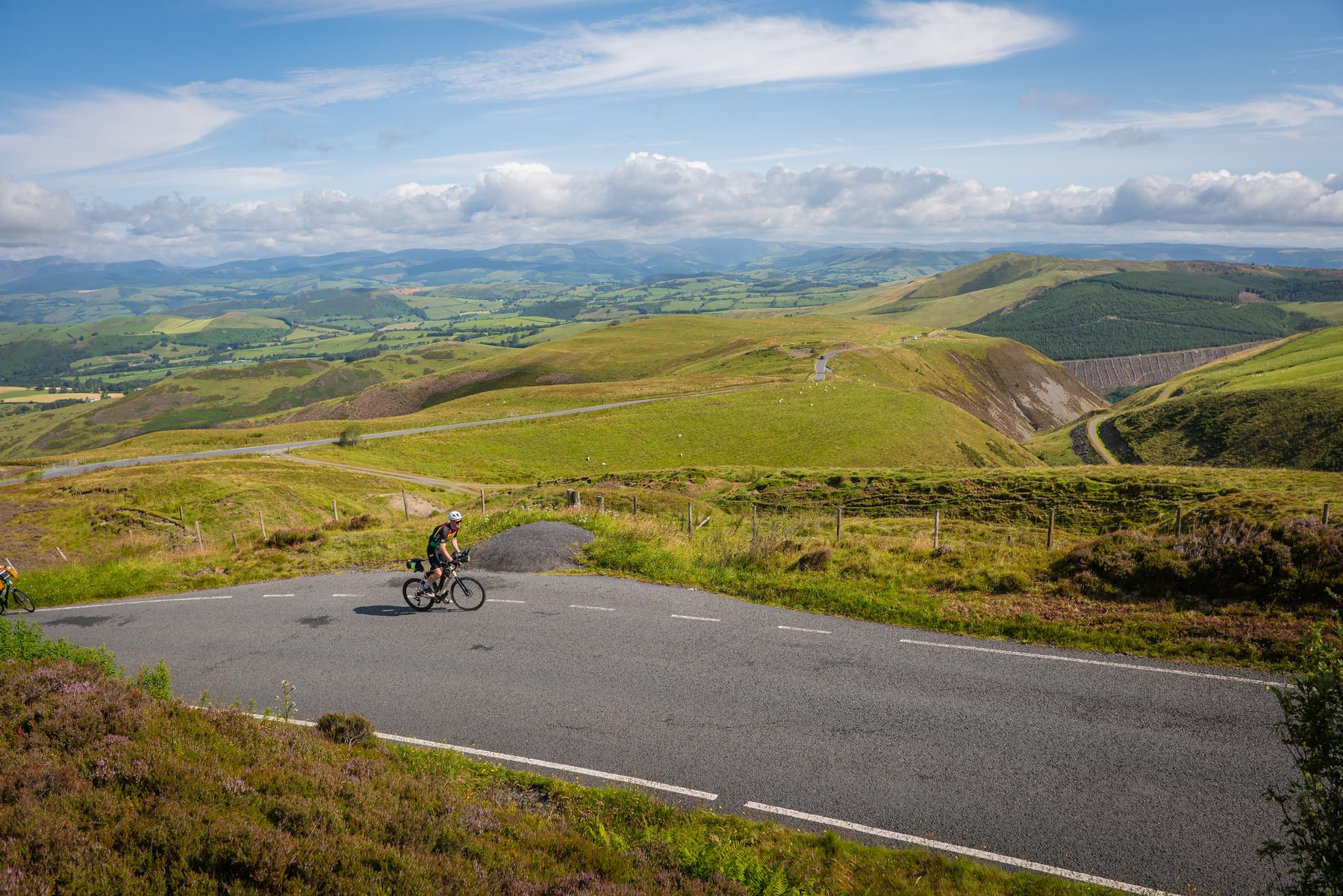 A rider rounding a hairpin between gorse on a Welsh mountain road